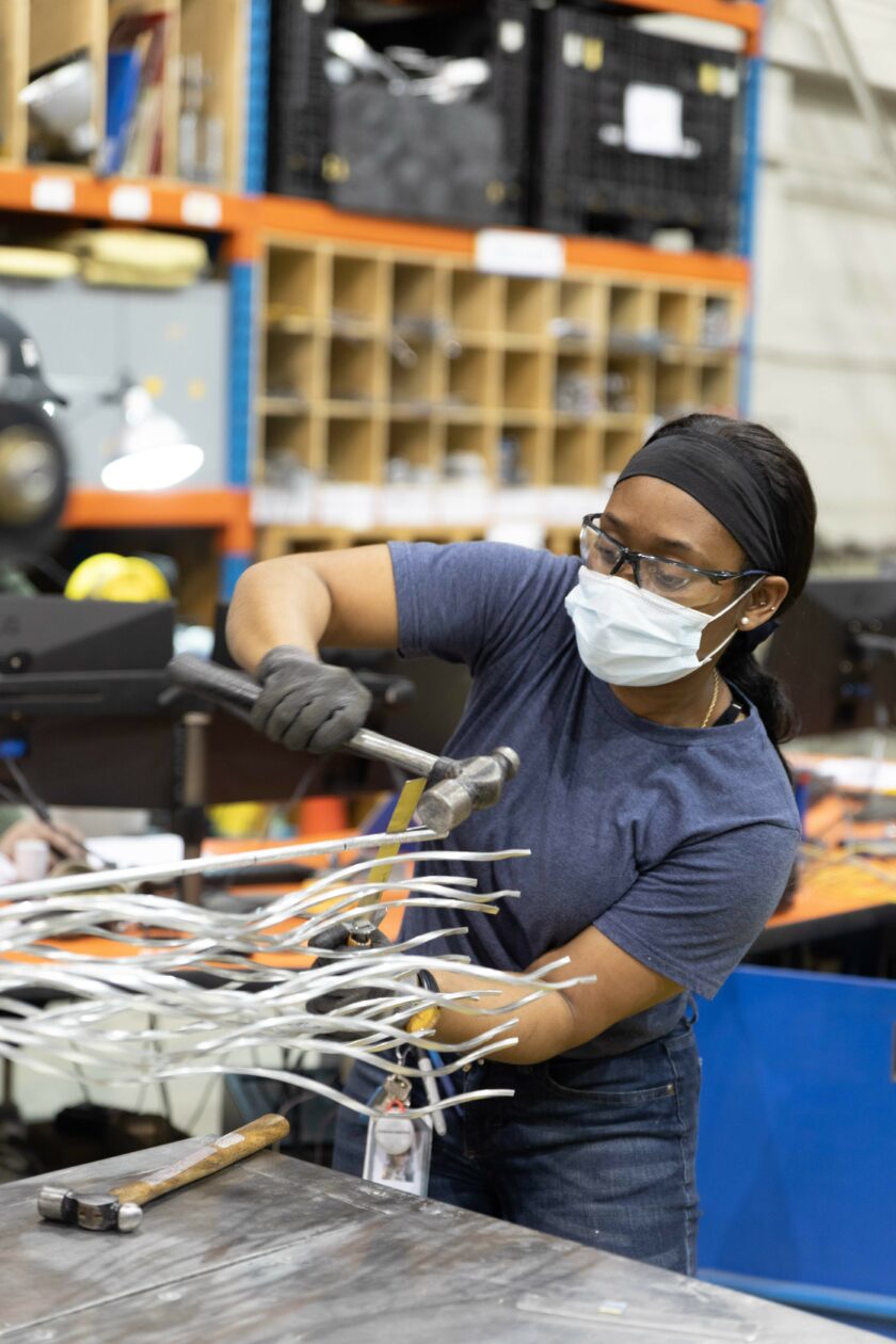 Photograph of a worker hammering a metal component